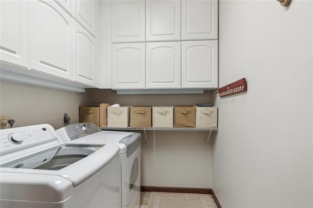 laundry area featuring separate washer and dryer and cabinets