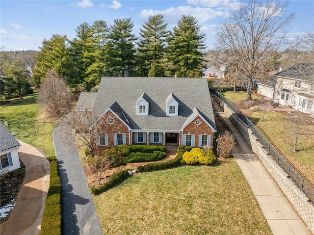 cape cod-style house with a front yard