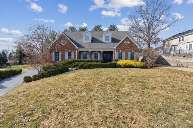 cape cod-style house featuring a front yard