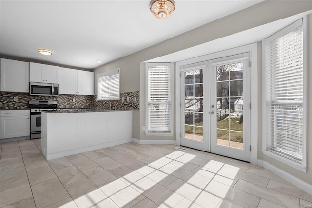 kitchen featuring backsplash, french doors, white cabinets, and appliances with stainless steel finishes