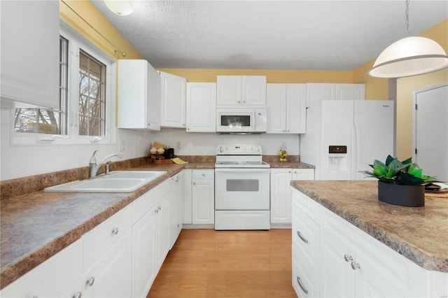 kitchen with decorative light fixtures, white cabinetry, sink, light hardwood / wood-style floors, and white appliances