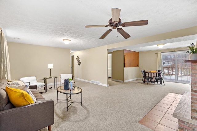 carpeted living room with ceiling fan and a textured ceiling