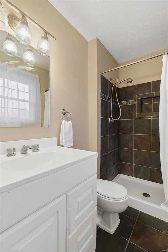 bathroom with tile patterned flooring, a textured ceiling, toilet, and walk in shower