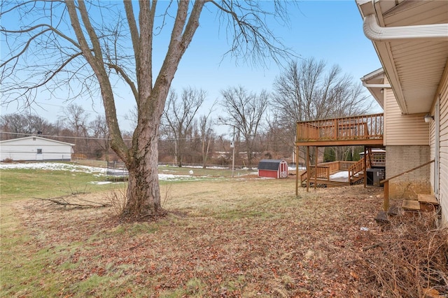 view of yard with a wooden deck, central AC, and a shed