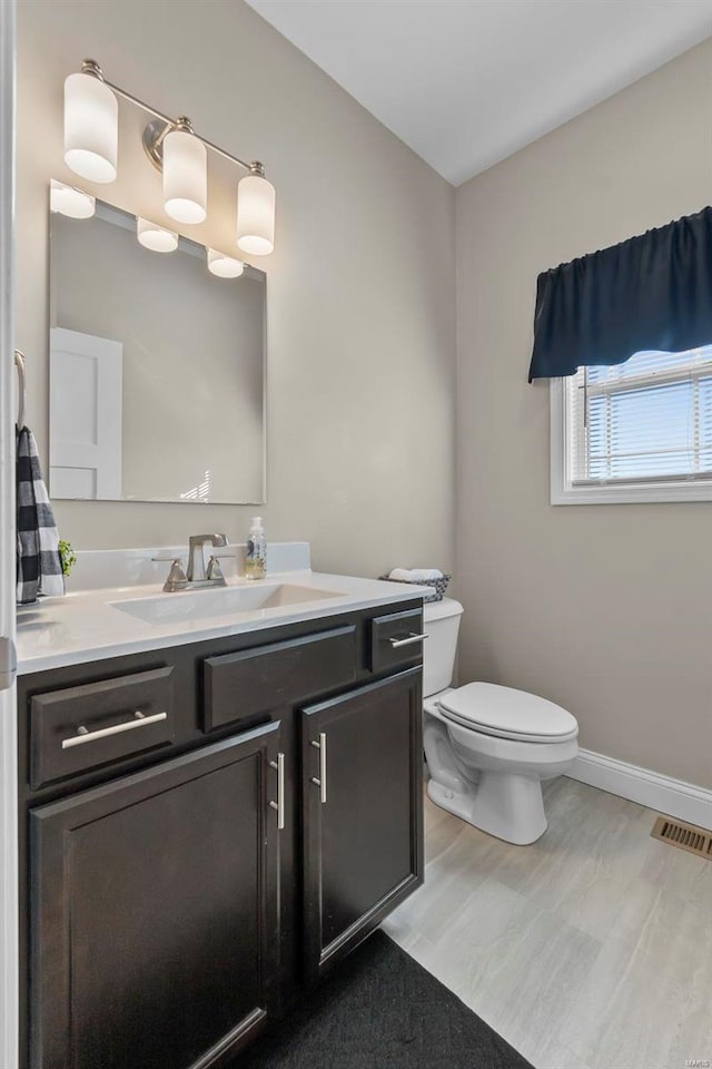 bathroom with vanity, hardwood / wood-style floors, and toilet