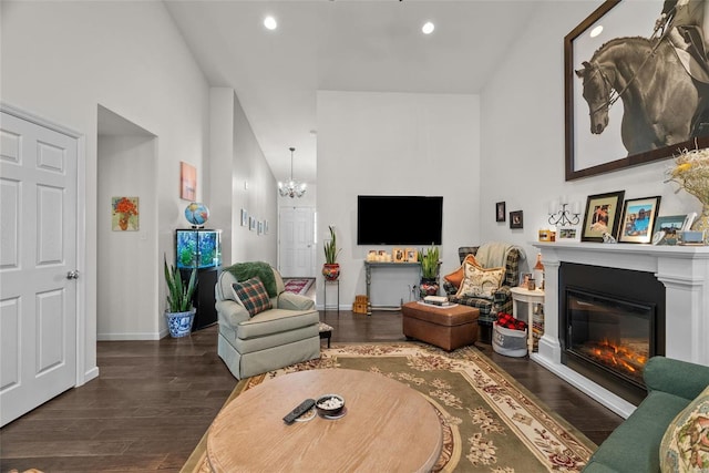 living room with an inviting chandelier, a towering ceiling, and dark hardwood / wood-style floors