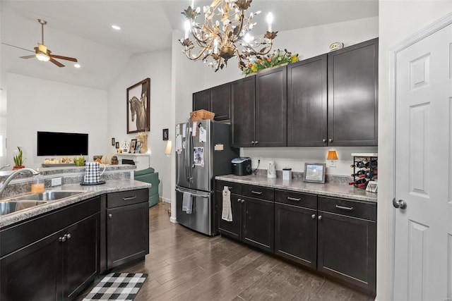 kitchen featuring dark hardwood / wood-style floors, pendant lighting, lofted ceiling, sink, and stainless steel fridge