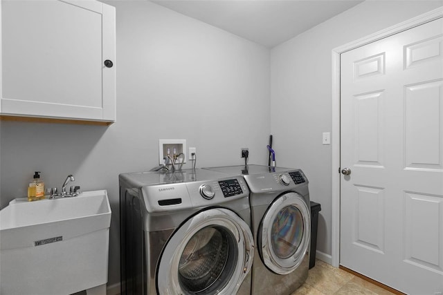 laundry area with independent washer and dryer, cabinets, and sink