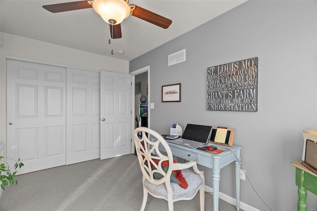 carpeted office space with ceiling fan