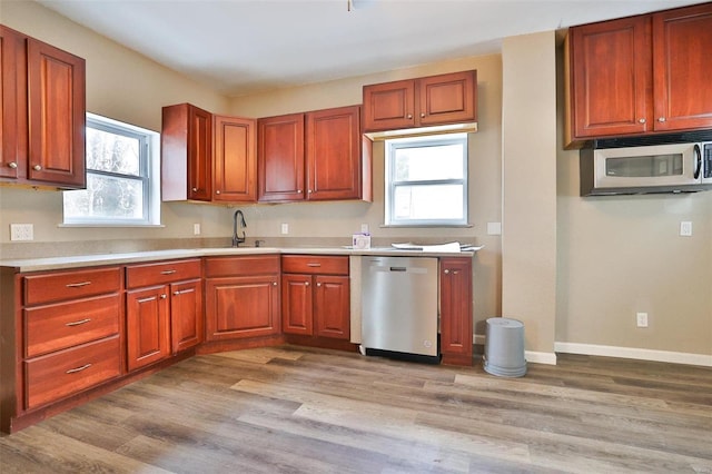 kitchen featuring light wood-type flooring, stainless steel appliances, and sink