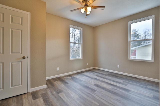 empty room with hardwood / wood-style flooring and ceiling fan