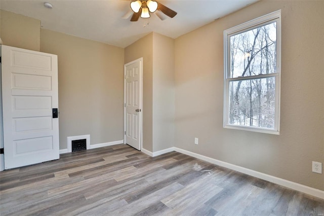 spare room with ceiling fan and wood-type flooring