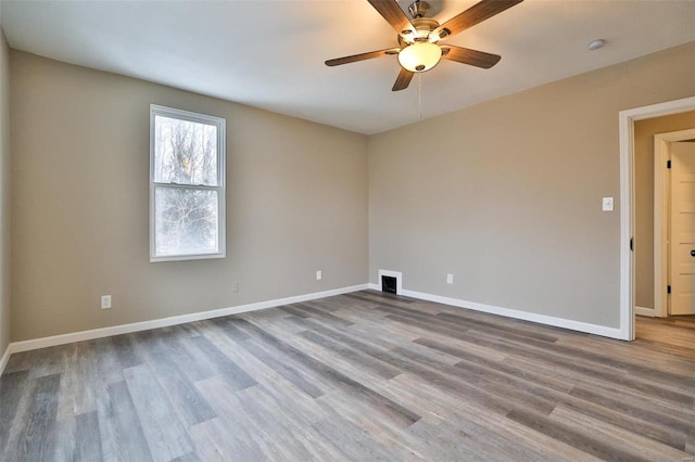 spare room with ceiling fan and wood-type flooring