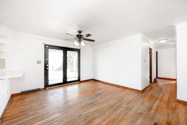 empty room with ceiling fan and light hardwood / wood-style floors