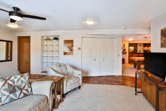 living area with ceiling fan and carpet floors