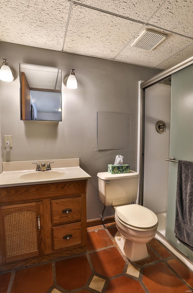 bathroom featuring vanity, a paneled ceiling, an enclosed shower, and toilet