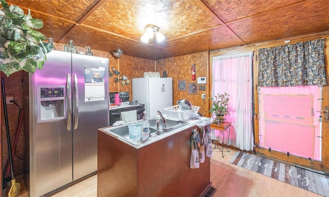 kitchen featuring a kitchen island, white fridge, light wood-type flooring, and stainless steel fridge with ice dispenser