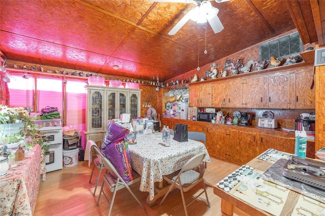 dining room with light hardwood / wood-style flooring, ceiling fan, and vaulted ceiling