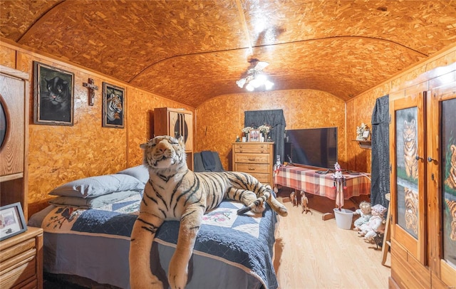 bedroom with lofted ceiling, wood-type flooring, and brick ceiling