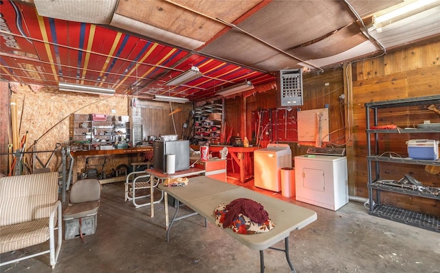 basement featuring washer and dryer, wooden walls, and a workshop area