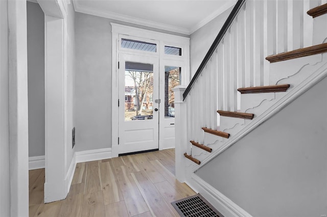 entrance foyer featuring ornamental molding and light hardwood / wood-style flooring