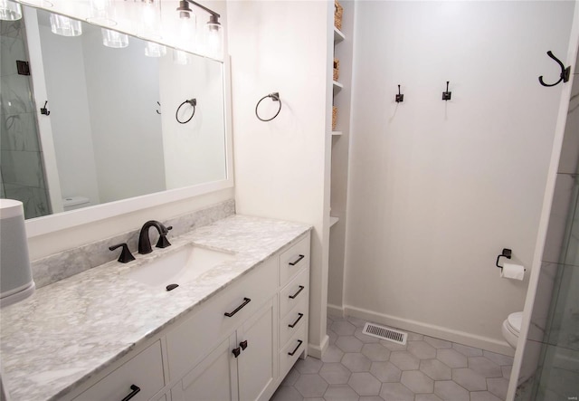 bathroom featuring tile patterned flooring, vanity, and toilet