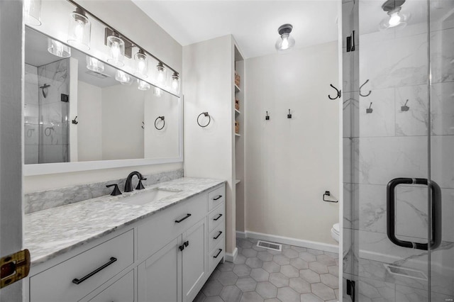 bathroom with vanity, toilet, a shower with shower door, and tile patterned flooring