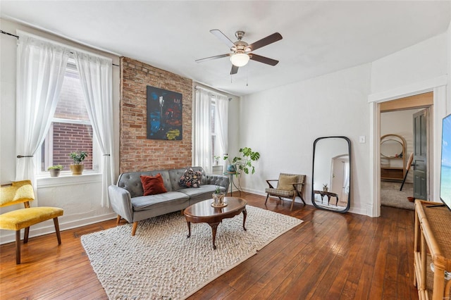 living room featuring dark wood-style floors, baseboards, and a ceiling fan