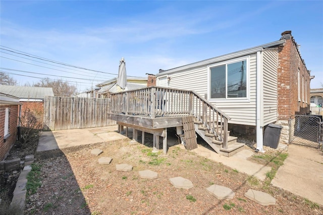 back of property featuring a deck and fence