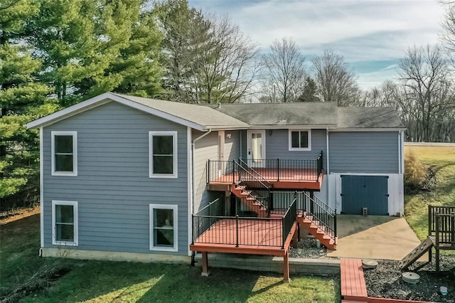 rear view of property featuring a lawn and a deck