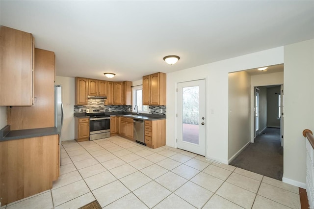 kitchen with tasteful backsplash, stainless steel appliances, sink, and light tile patterned floors