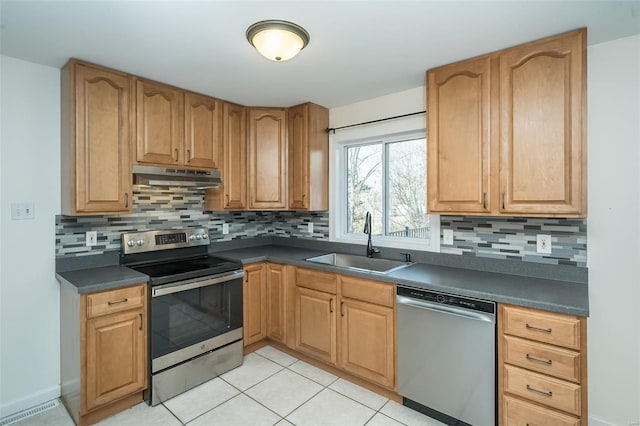 kitchen featuring appliances with stainless steel finishes, sink, light tile patterned floors, and decorative backsplash