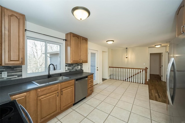 kitchen featuring sink, light tile patterned floors, stainless steel appliances, and backsplash