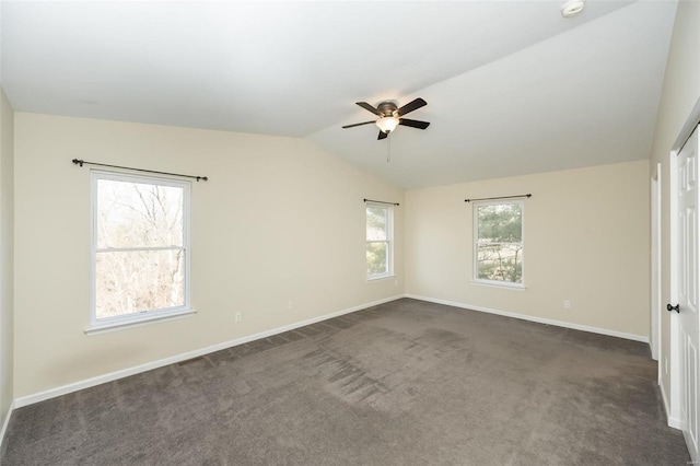 empty room with dark colored carpet, lofted ceiling, and ceiling fan