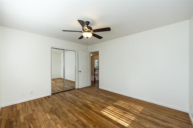 unfurnished bedroom featuring hardwood / wood-style floors, ceiling fan, and a closet