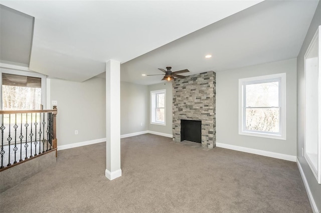 unfurnished living room featuring ceiling fan, carpet flooring, and a fireplace