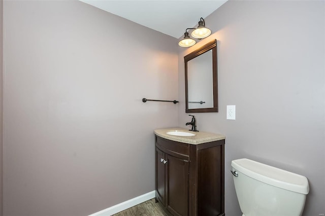 bathroom with vanity, toilet, and wood-type flooring