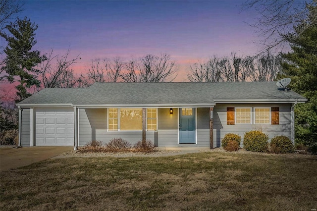 ranch-style house featuring a garage and a yard