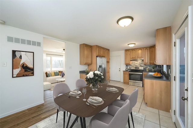 kitchen featuring appliances with stainless steel finishes, sink, decorative backsplash, and light tile patterned floors