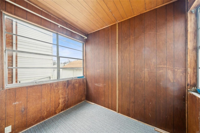 spare room with wooden walls, carpet floors, and wooden ceiling