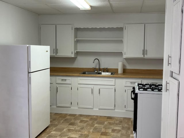 kitchen with sink, gas range, white cabinets, and white fridge