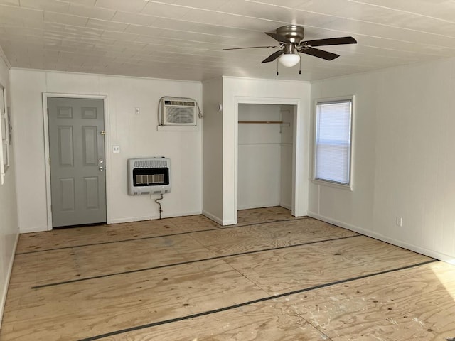 unfurnished bedroom featuring a wall mounted air conditioner, heating unit, and ceiling fan