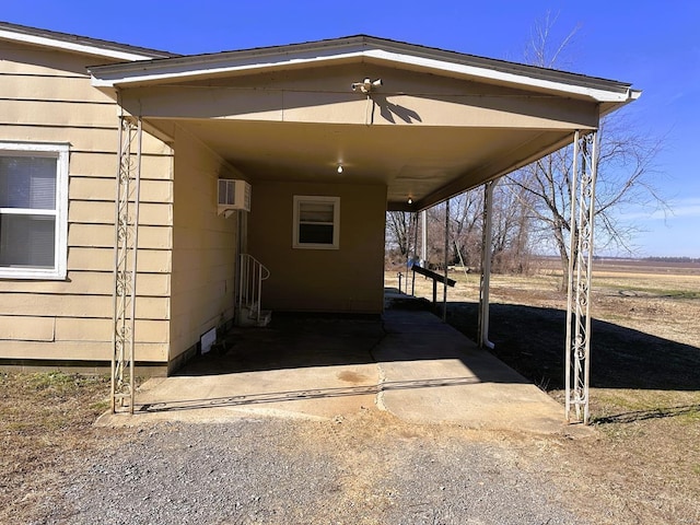 view of side of property with a carport and an AC wall unit