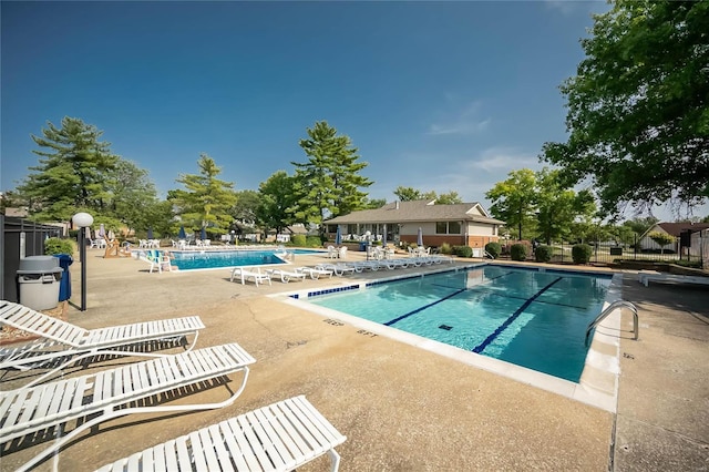 pool featuring fence and a patio area