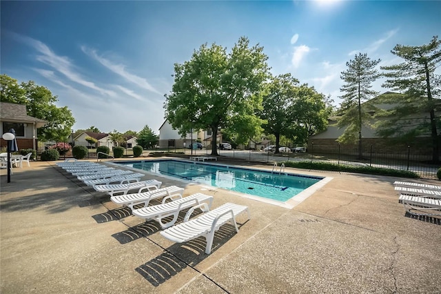 community pool with fence and a patio