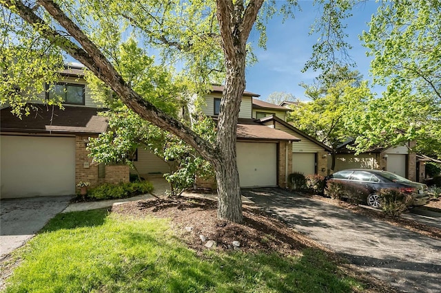 obstructed view of property featuring brick siding, aphalt driveway, and a garage