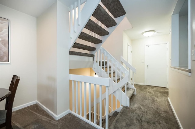 staircase with baseboards and carpet floors