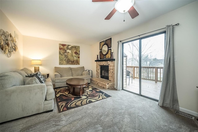 carpeted living area with a fireplace, visible vents, and a ceiling fan