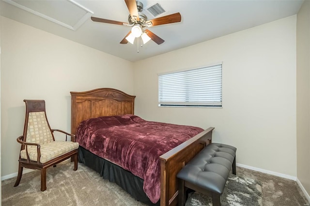 carpeted bedroom featuring attic access, visible vents, baseboards, and ceiling fan