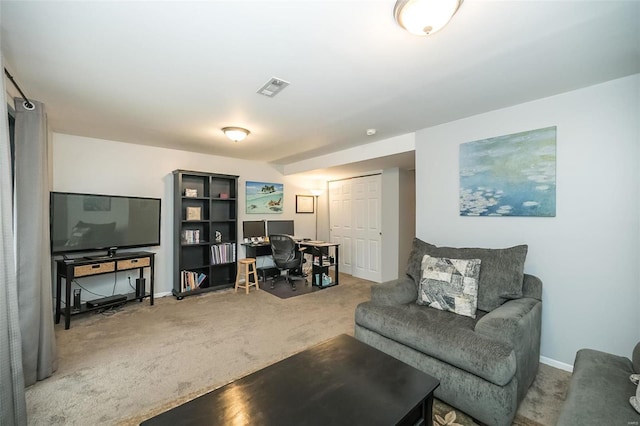 living area with baseboards, visible vents, and carpet